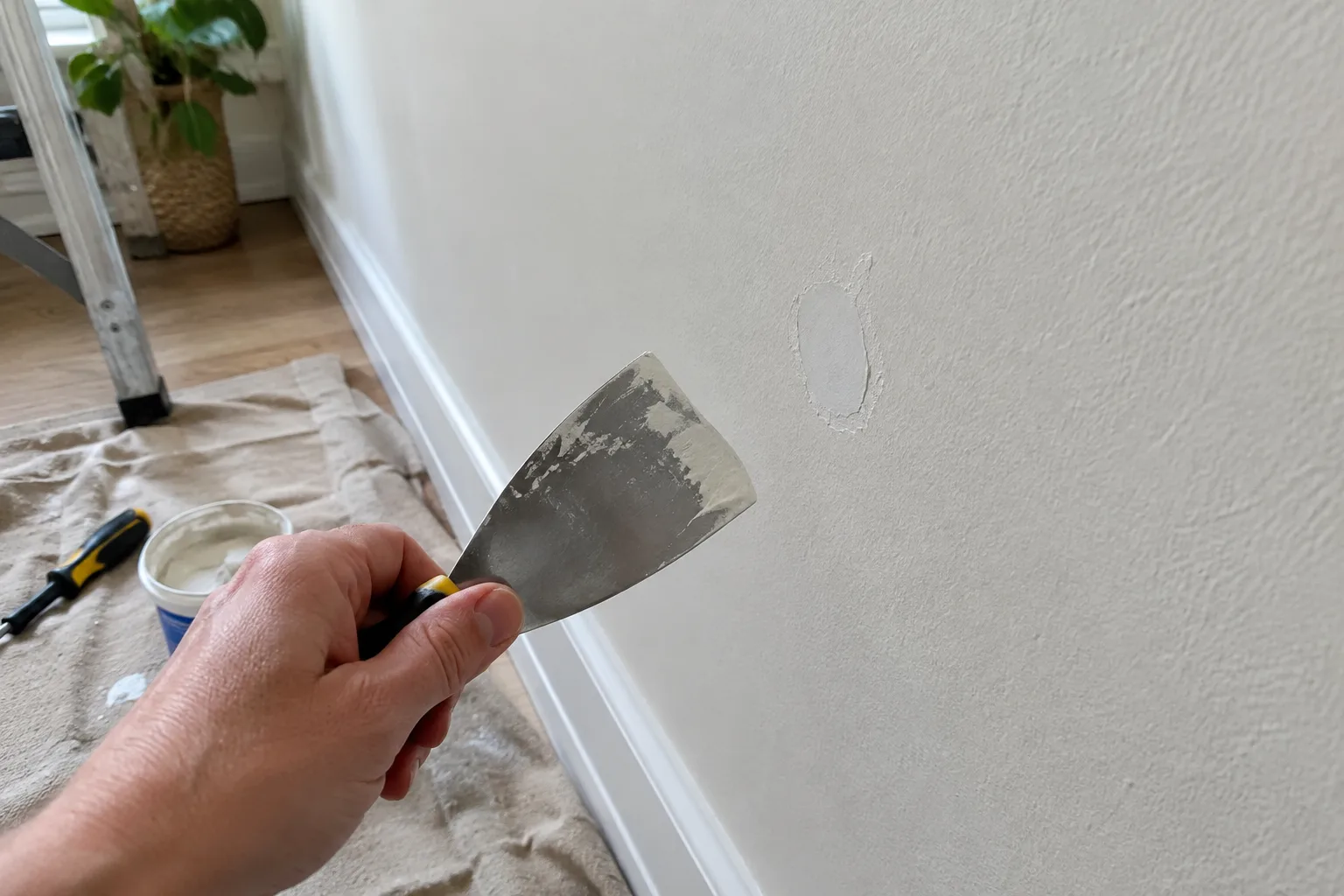 Une petite cavité rebouchée sur un mur en plâtre avant l’application de la peinture.